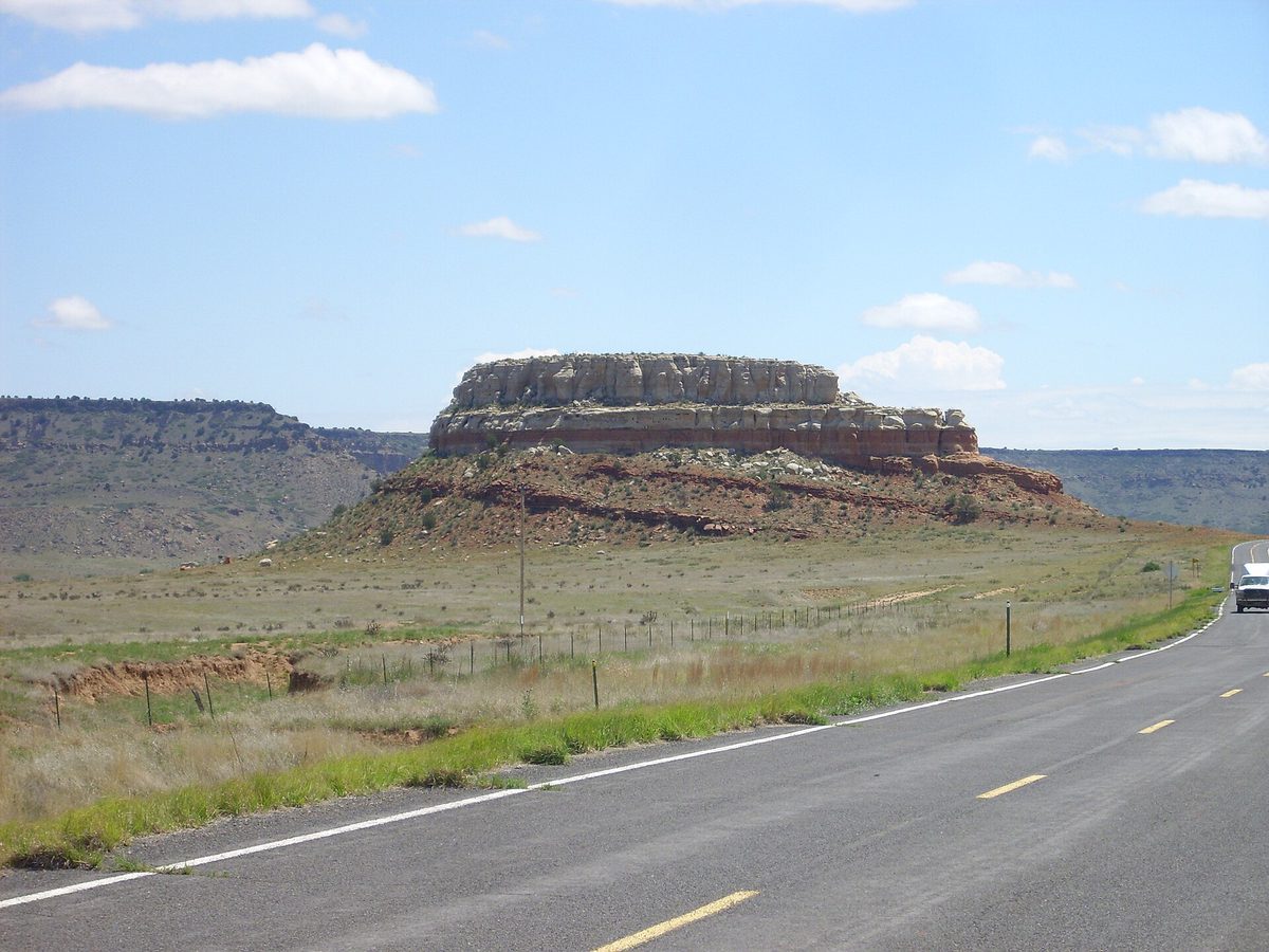 A flat-topped butte with clearly banded horizontal rock layers exposed in its sides, each layer a different colour and thickness.